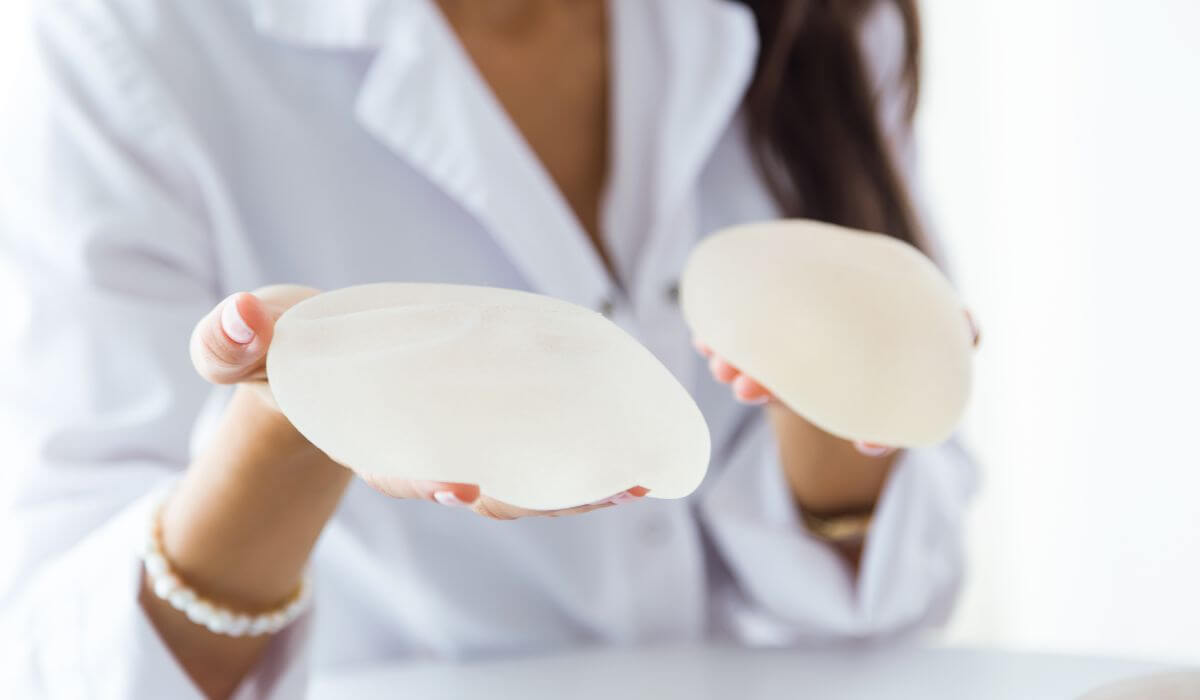 femme avec deux protheses mammaires dans les mains